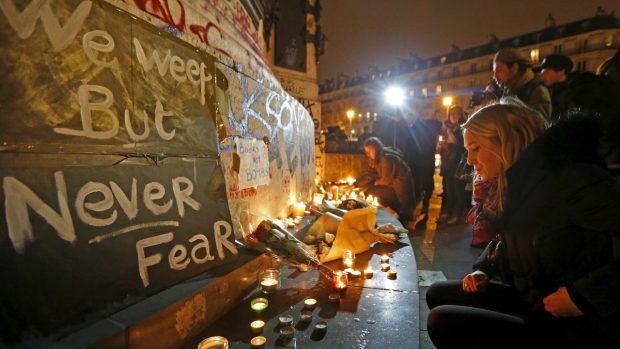 Pláčeme, ale nebojíme se. Transparent obklopený svíčkami a květinami, které Francouzi spontánně kladou nedaleko míst teroristických útoků v Paříži